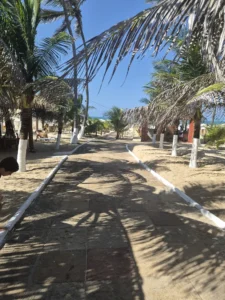 Entrada da Barraca Itaparika, com coqueiros e cabanas na Praia do Futuro, Fortaleza