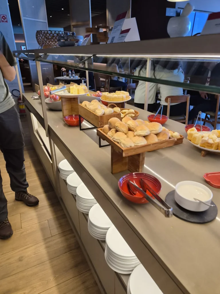 Cesta de pão de queijo e tábua de queijos na sala Bradesco Lounge de Congonhas