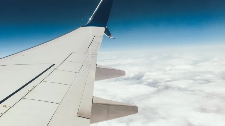 Asa de avião sobre um mar de nuvens