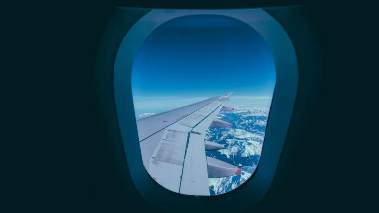 Asa de avião sobre montanhas nevadas