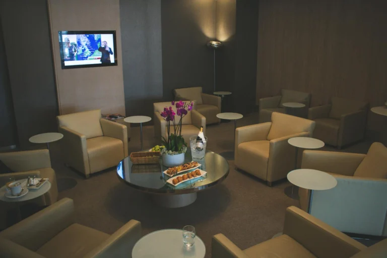 Interior de sala VIP de aeroporto com poltronas de couro e ambiente premium