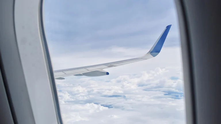 Asa de avião acima das nuvens a caminho da Ásia