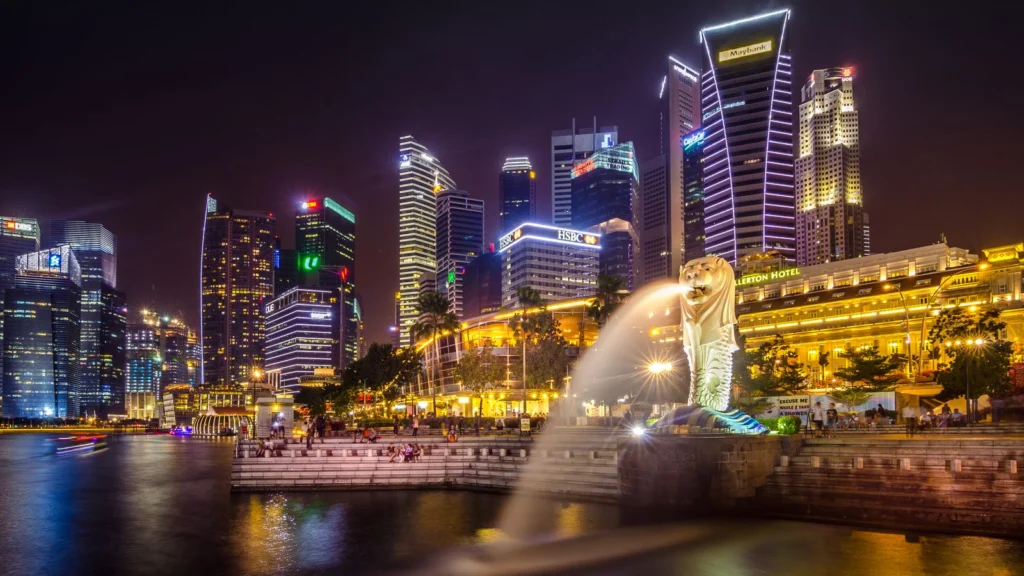 Skyline de Singapura à noite, com o Merlion e as torres da Marina Bay