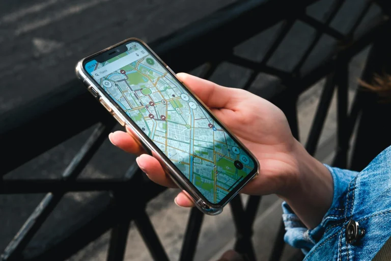 Mao segurando smartphone com aplicativo de mapa durante viagem