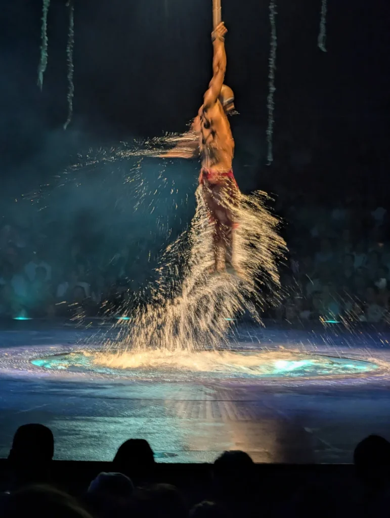 Performer suspenso durante número aquático do Cirque du Soleil LUZIA. Foto própria, 2026.