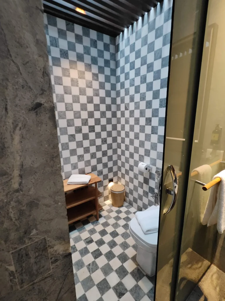 Banheiro do Hotel Clara revestido de mármore e pedra mineira em padrão xadrez