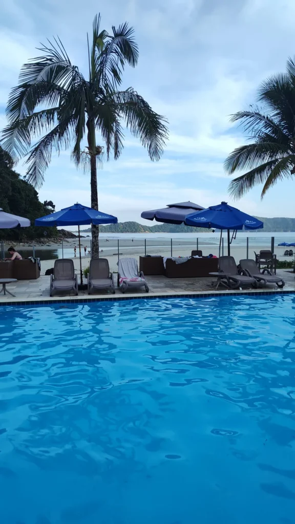 Piscina do Juquehy Praia Hotel com vista para a serra e coqueiros. Foto própria, 2026.