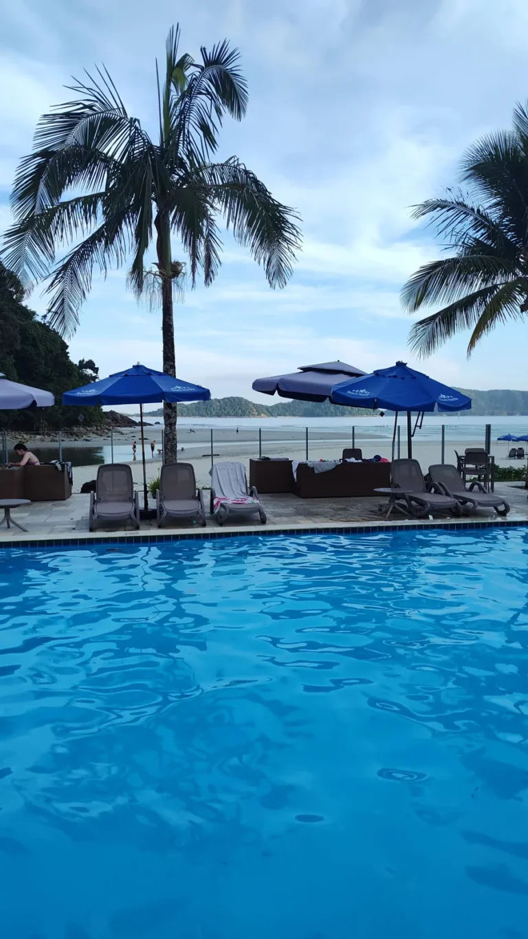 Piscina do Juquehy Praia Hotel com vista para a serra e coqueiros. Foto própria, 2026.