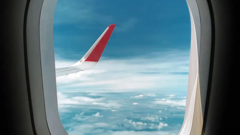 Asa de avião sob céu azul, ilustrando a Tarifa Congelada da Azul