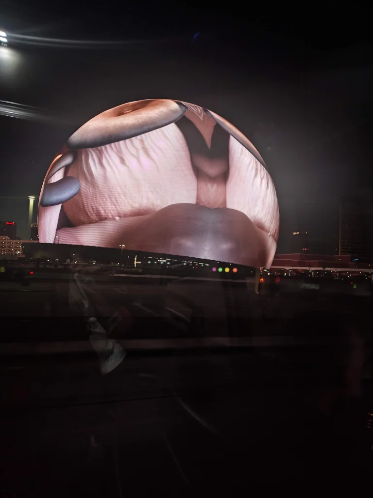 Fachada de LED da The Sphere iluminada à noite em Las Vegas, com animação em tons claros