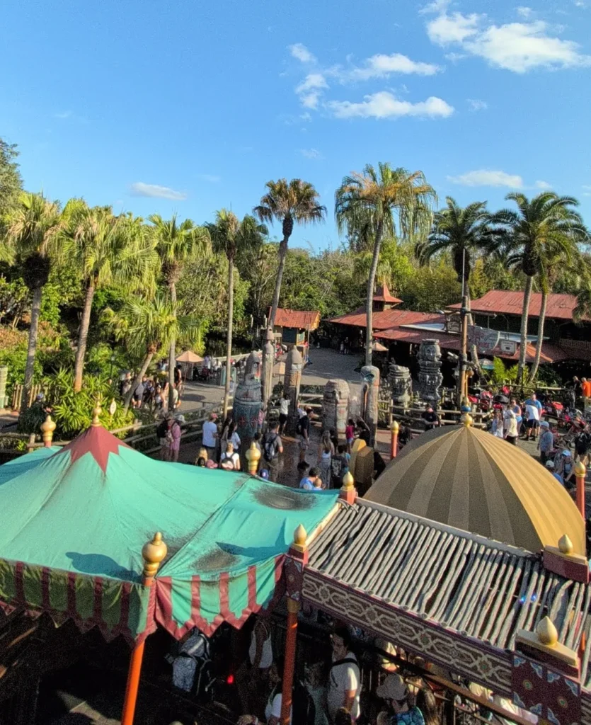 Vista de Adventureland no Magic Kingdom a partir da atração The Magic Carpets of Aladdin, com palmeiras e telhados temáticos. Foto própria, março de 2026.