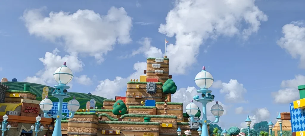 Montanha cenográfica da Super Nintendo World no Universal Epic Universe, com Thwomps, blocos de interrogação e a loja Mario Motors à esquerda. Foto própria, abril de 2026.
