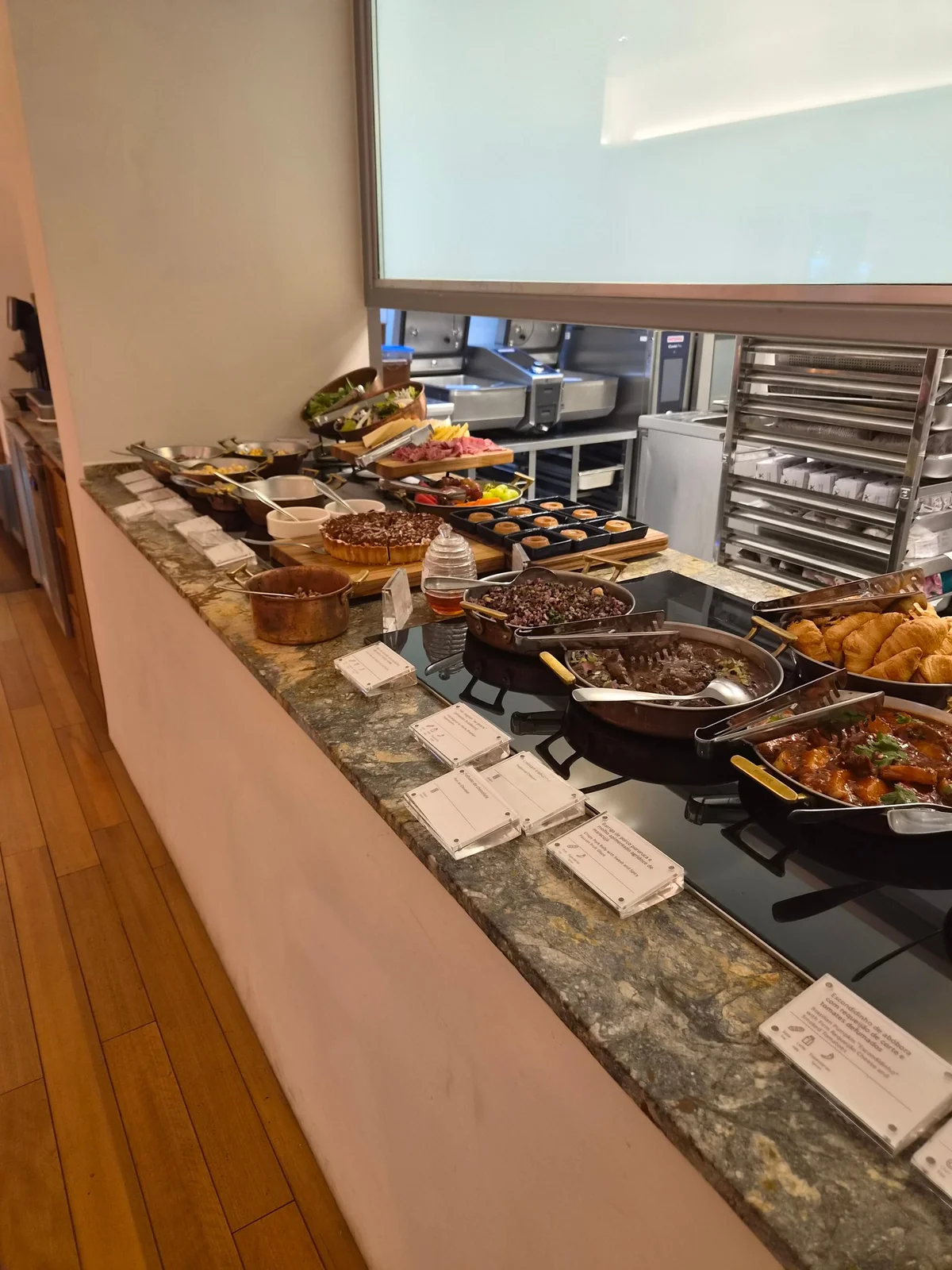 Estação de buffet da Sala Pedra Preta com cooktops de indução, panelas de cobre, pratos quentes e pães
