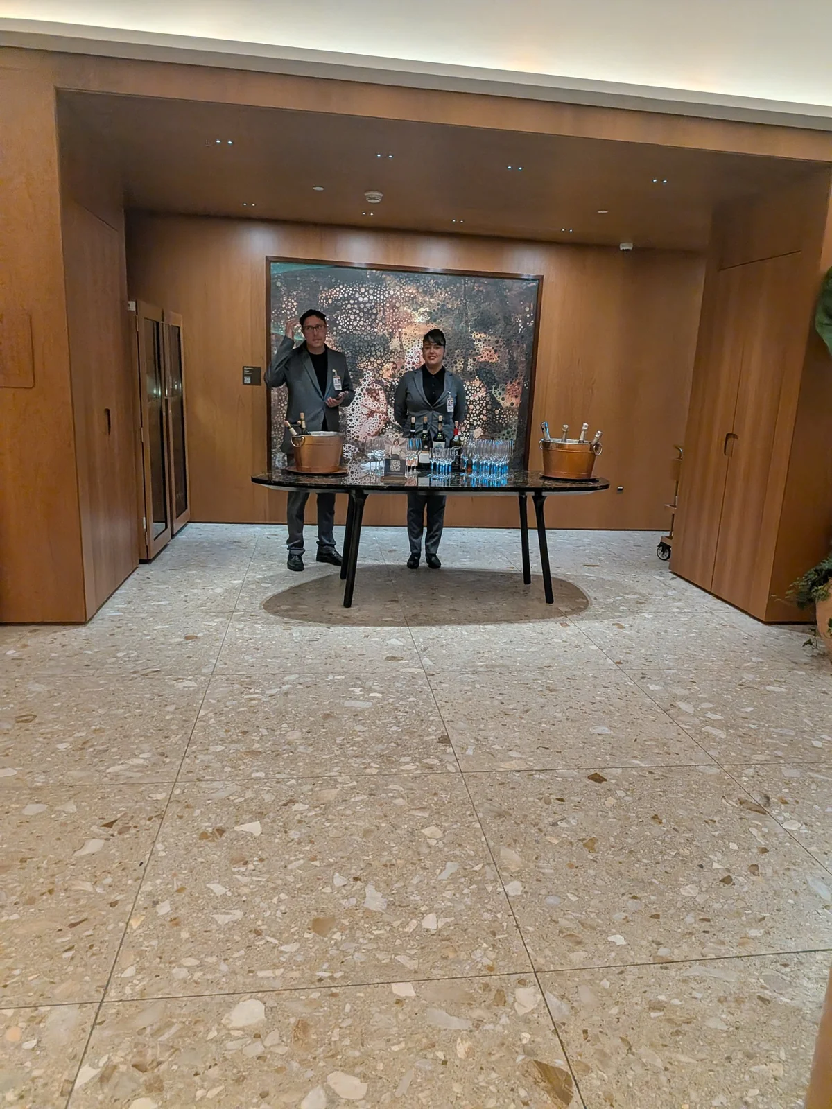 Mesa de degustação de vinhos da Sala Pedra Preta com sommeliers em traje social, baldes de cobre e taças