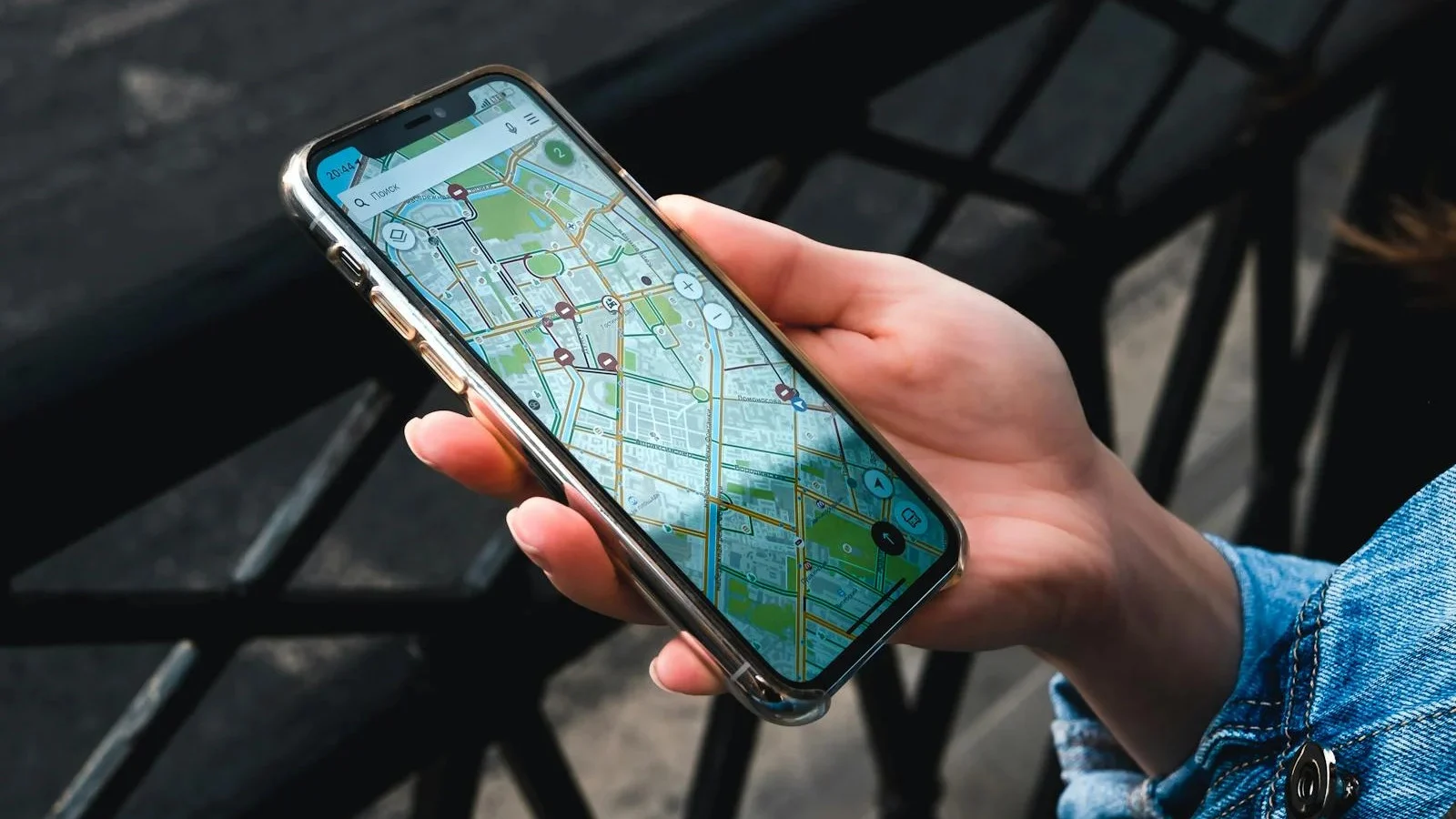 Mão segurando um smartphone com aplicativo de mapa, imagem ilustrativa de internet em viagem
